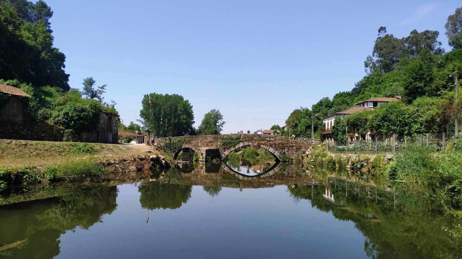 Ponte histórica refletida no rio Vizela